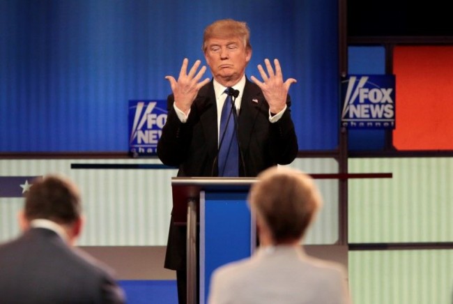 Republican U.S. presidential candidate Donald Trump shows off the size of his hands as Fox News Channel moderators Brett Baier (L) and Megyn Kelly (R) look on at the U.S. Republican presidential candidates debate in Detroit, Michigan, March 3, 2016. REUTERS/Rebecca Cook