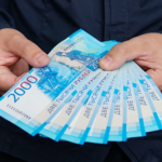 new Russian banknotes denominated in 2000 rubles in male hands close-up on a dark background