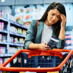 adult woman feeling worried about grocery prices while shopping in supermarket.