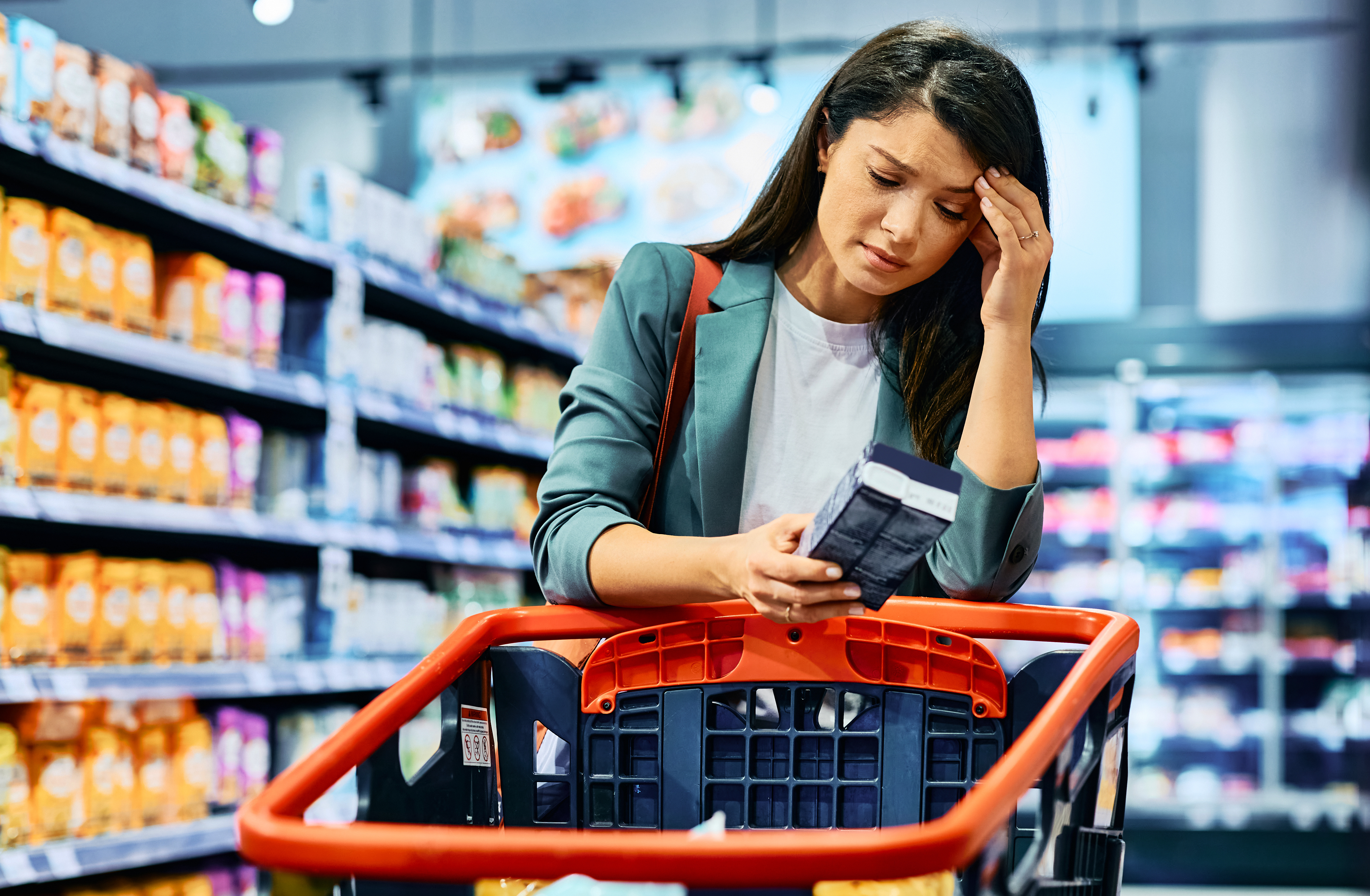 adult woman feeling worried about grocery prices while shopping in supermarket.