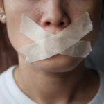 woman with mouth sealed in adhesive tape